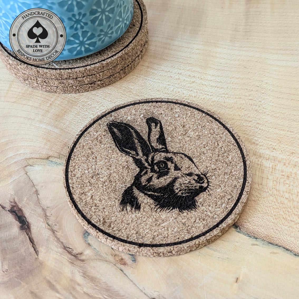 Cork coaster with rabbit illustration on a wooden surface